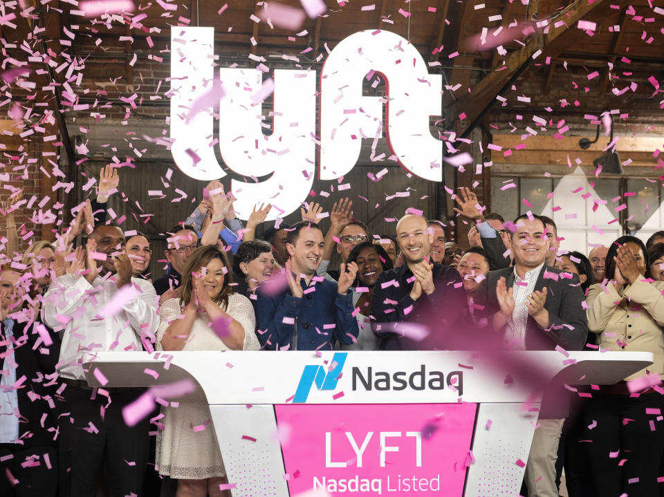 Lyft co-founders John Zimmer, front third from left, and Logan Green, front third from right, cheer as they as they ring a ceremonial opening bell in Los Angeles, Friday, March 29, 2019. On Friday the San Francisco company's stock will begin trading on the Nasdaq exchange under the ticker symbol "LYFT." (AP Photo/Ringo H.W. Chiu)