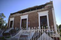 A fence and building are partially collapsed after an overnight earthquake in Guayanilla, Puerto Rico, Tuesday, Jan. 7, 2020. A 6.4-magnitude earthquake struck Puerto Rico before dawn on Tuesday, killing one man, injuring others and collapsing buildings in the southern part of the island. (AP Photo/Carlos Giusti)