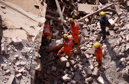 Rescue workers look for survivors amidst the rubble at the site of a collapsed residential building at Shah Beri village in Greater Noida, July 18, 2018. REUTERS/Adnan Abidi