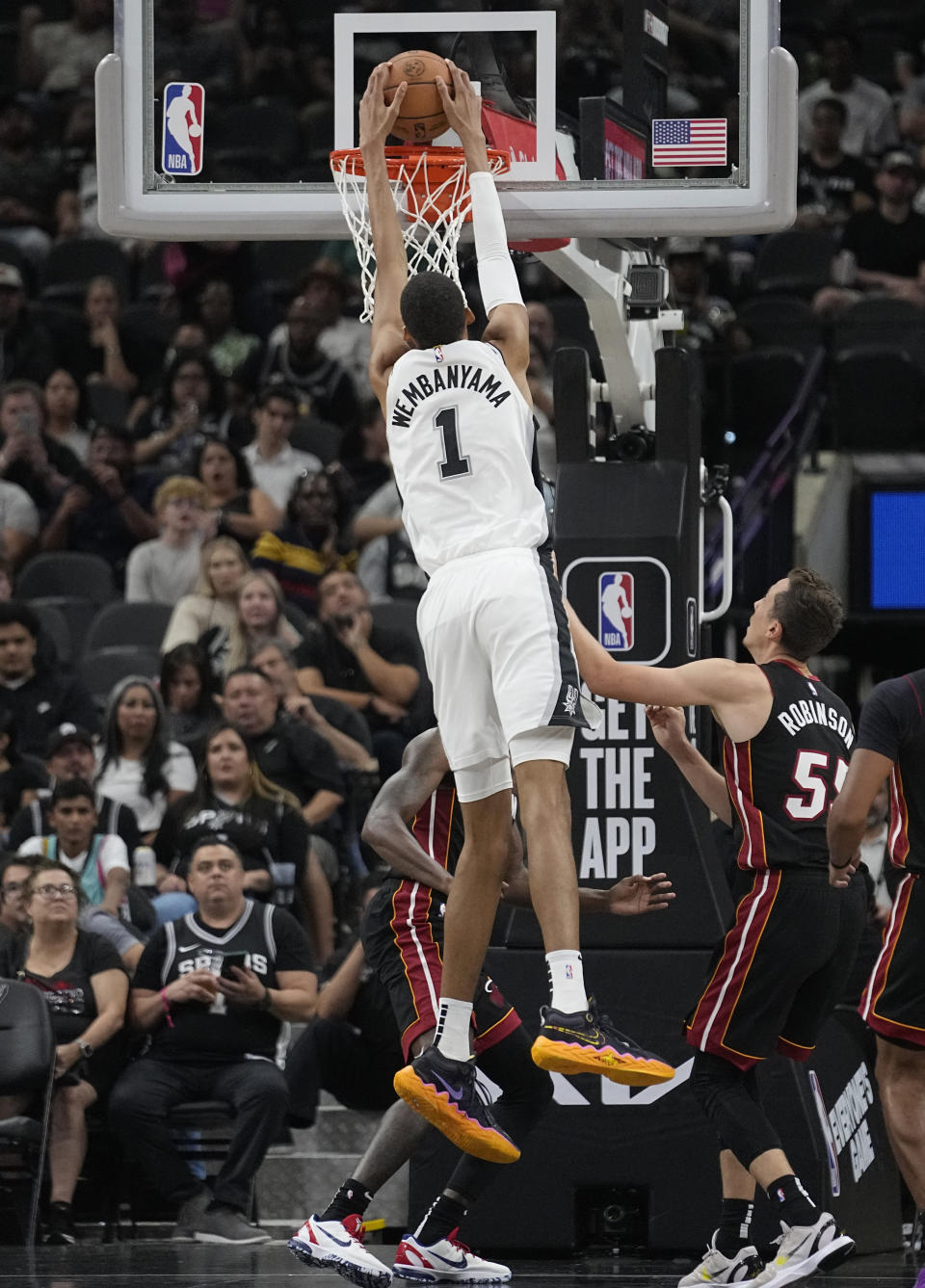 San Antonio Spurs center Victor Wembanyama (1) scores against the Miami Heat during the first half of a preseason NBA basketball game in San Antonio, Friday, Oct. 13, 2023. (AP Photo/Eric Gay)