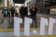 In this photo taken Sunday, Nov. 10, 2019, shoppers react as they take part in a promotion ahead of Nov. 11 Singles day in Beijing. Chinese online shoppers hunt bargains on Singles Day, a holiday invented in the 1990s that has become the world's busiest day for online commerce. (AP Photo/Ng Han Guan)