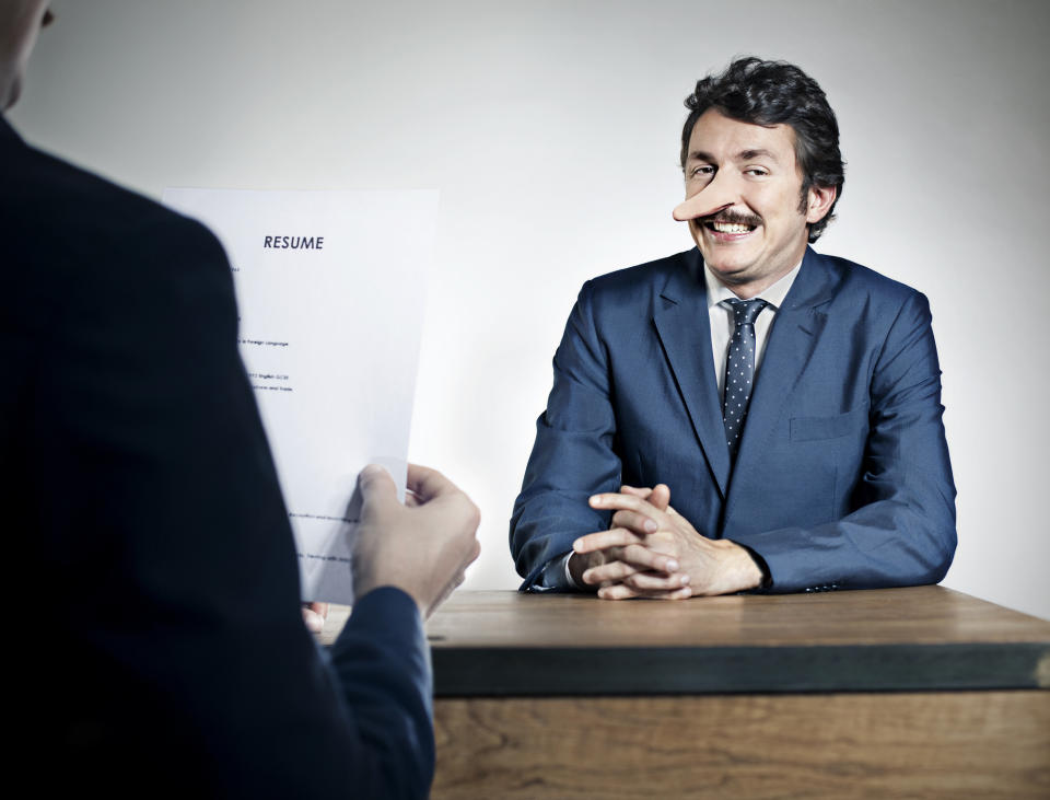 Person with a pen in nose smiles during a job interview, likely humor related to the "Tasty" category