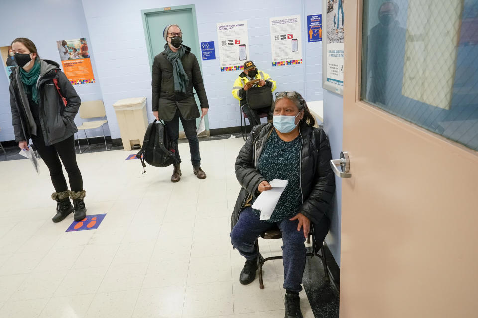 Maria Hernandez, right, of Manhattan, sits in a waiting area after registering for the first dose of the coronavirus vaccine at a COVID-19 vaccination site at NYC Health + Hospitals Metropolitan, Thursday, Feb. 18, 2021, in New York. (AP Photo/Mary Altaffer)