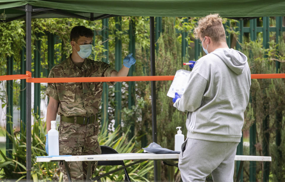 Members of the military operate a walk-in mobile Covid-19 testing centre at Spinney Hill Park in Leicester, England, Monday June 29, 2020. The British government is reimposing lockdown restrictions in the central England city of Leicester after a spike in coronavirus infections, including the closure of shops that don’t sell essential goods and schools. (Joe Giddens/PA via AP)