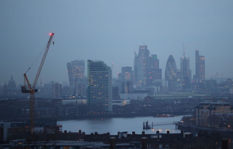 The City of London financial district is seen during early morning mist from Greenwich Park in London