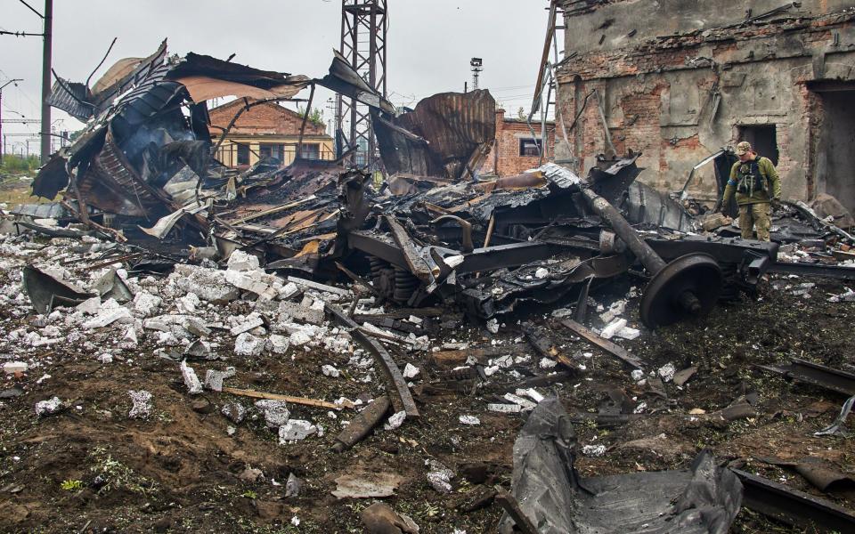 A Ukrainian soldier checks a destroyed freight wagon struck by Russian shelling in Kharkiv - SERGEY KOZLOV/EPA-EFE/Shutterstock