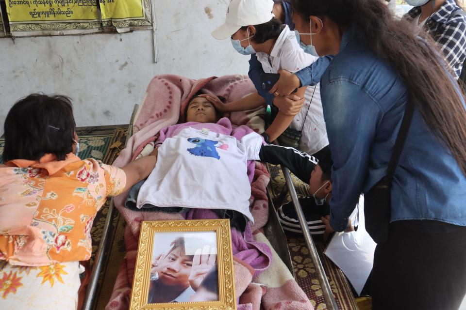 Family members grieve over the body of Tun Tun Aung at a cemetery in Mandalay, March 23, 2021, a day after he was shot dead in front of his home by security forces during a crackdown on demonstrations against the military coup. / Credit: STR/AFP/Getty