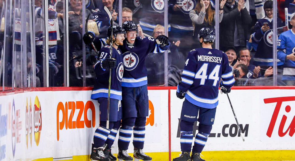 WINNIPEG, MB - OCTOBER 10: Kyle Connor #81, Patrik Laine #29 and Josh Morrissey #44 of the Winnipeg Jets celebrate a third period goal against the Minnesota Wild at the Bell MTS Place on October 10, 2019 in Winnipeg, Manitoba, Canada. (Photo by Darcy Finley/NHLI via Getty Images)