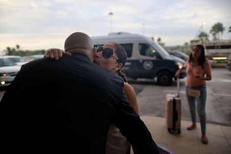 Alejandra Juarez kisses Alex Barrio (L), an aide for U.S. Rep. Darren Soto (D-FL) as she arrives for her deportation flight to Mexico under U.S. President Donald Trump’s administration’s zero-tolerance immigration policy at the Orlando International Airport in Orlando, Florida, U.S., August 3, 2018. REUTERS/Joey Roulette