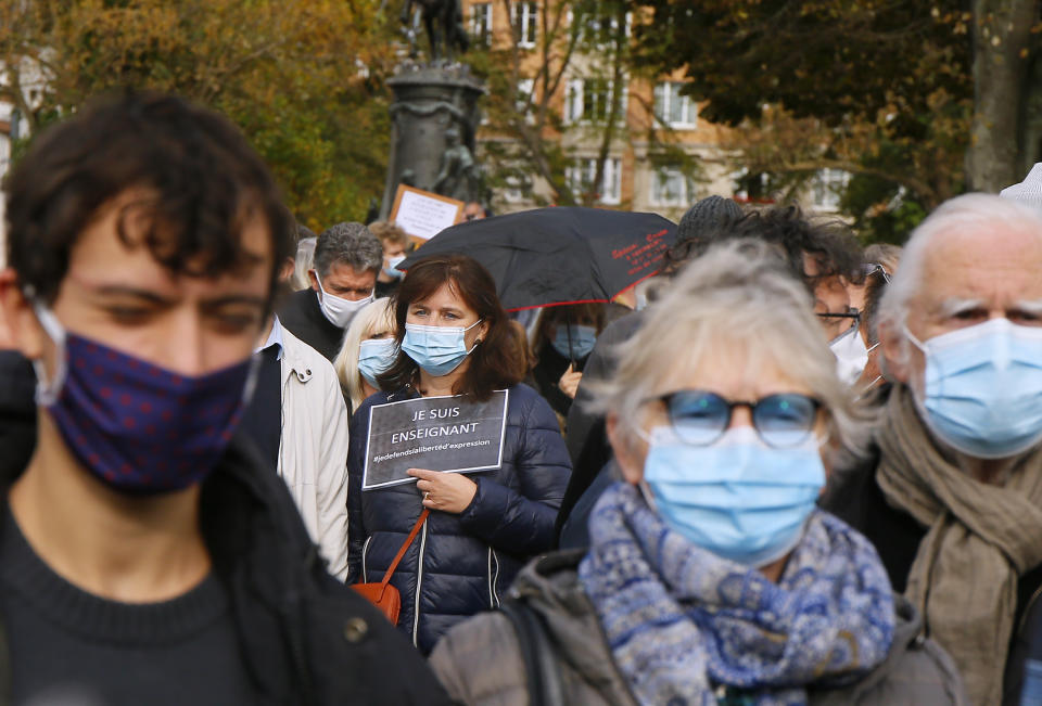 A person holds up a a poster that reads: "I am a Teacher", as they gather on Republique square in Lille, northern France, Sunday Oct. 18, 2020. Demonstrators in France on Sunday took part in gatherings in support of freedom of speech and in tribute to a history teacher who was beheaded near Paris after discussing caricatures of Islam’s Prophet Muhammad with his class. (AP Photo/Michel Spingler)