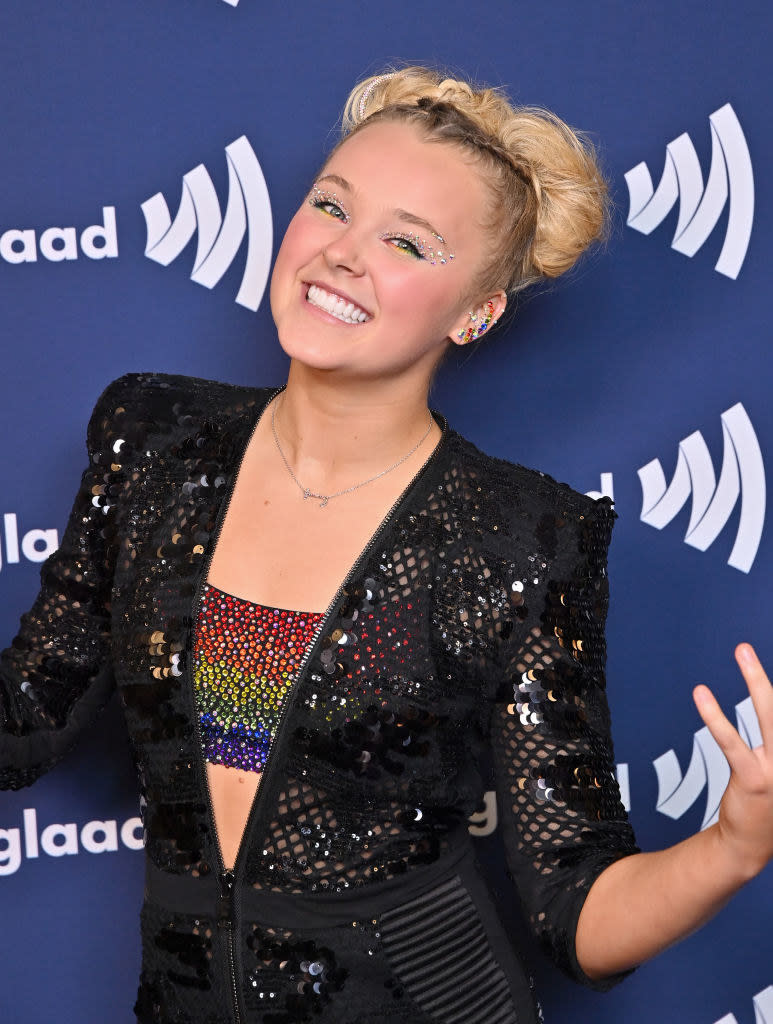 JoJo Siwa smiles and makes a motion with her hands