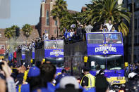 Buses carrying Los Angeles Rams players and coaches drive past fans during the team's victory parade in Los Angeles, Wednesday, Feb. 16, 2022, following their win Sunday over the Cincinnati Bengals in the NFL Super Bowl 56 football game. (AP Photo/Marcio Jose Sanchez)