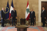 FILE - In this Aug.6, 2020 file photo, French President Emmanuel Macron, second left, and Lebanese President Michel Aoun, second right, meet at Beirut–Rafic Hariri International Airport, in Lebanon. In the wake of Beirut's massive port explosion, Macron has taken a tough line, setting deadlines for Lebanon's politicians to carry out reforms. His hands-on approach has angered some in Lebanon and brought praise from others. (AP Photo/Thibault Camus, Pool, File)