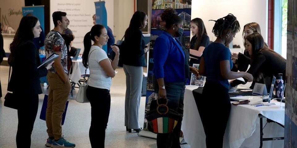 Job seekers at a job fair are standing in a line