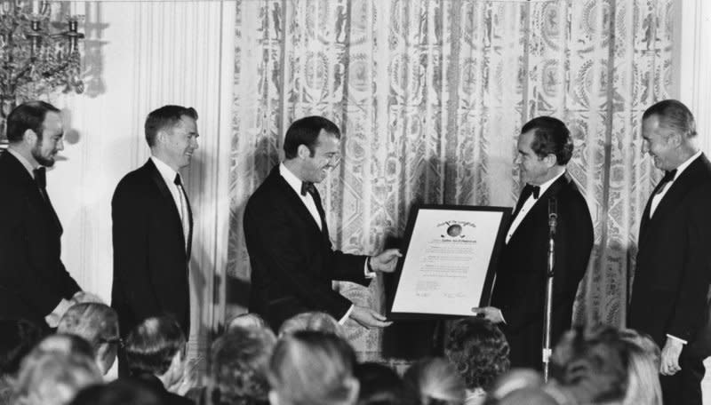 President Richard Nixon (2nd-R) awards the moon-voyaging astronauts of Apollo 14, Edgar Mitchell (L), Stuart Roosa (2nd-L) and Alan Shepard (C) with NASA’s Distinguished Service Medal at a White House dinner on March 1, 1971. Shepard and Mitchell walked on the moon February 5, 1971. File Photo by John Full/UPI