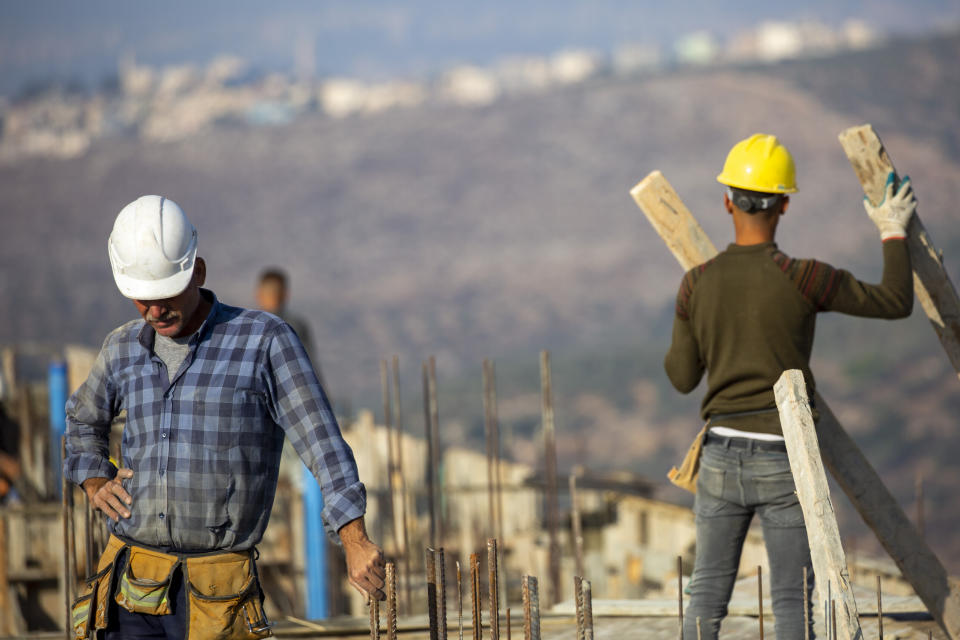 Palestinians built new houses in the West Bank Jewish settlement of Bruchin near the Palestinian town of Nablus, Monday, Oct. 25, 2021. Israel is expected to move forward with thousands of new homes for Jewish settlers in the West Bank this week, a settlement watchdog group said Sunday. (AP Photo/Ariel Schalit)