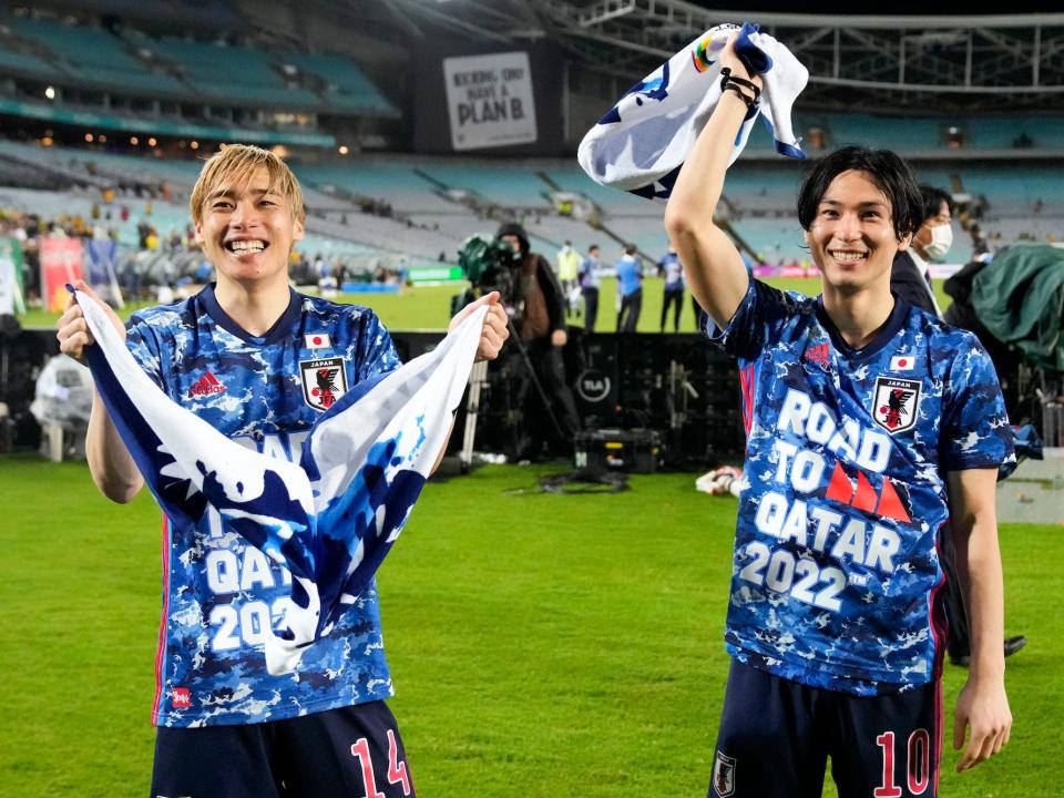 Japan's Junja Ito (left) and Takumi Minamino, right, wave to fans after a match.