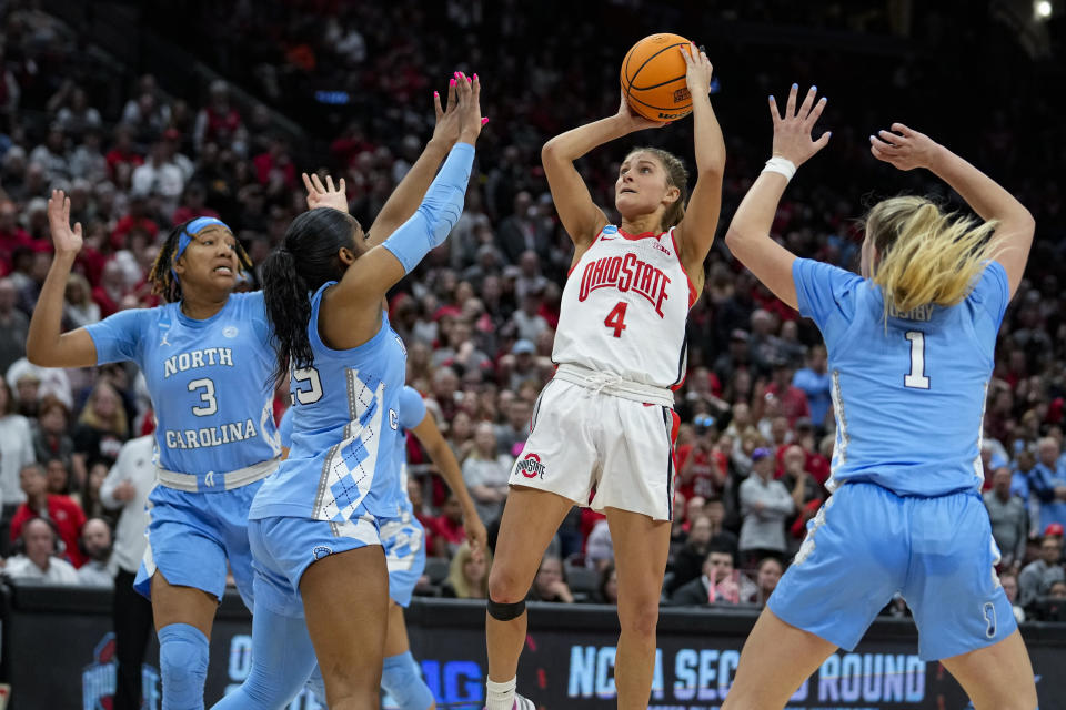 Ohio State guard Jacy Sheldon (4) hits a game-winning shot over North Carolina guard Deja Kelly (25) and guard Alyssa Ustby (1) in the second half of a second-round college basketball game in the women's NCAA Tournament in Columbus, Ohio, Monday, March 20, 2023. Ohio State defeated North Carolina 71-69. (AP Photo/Michael Conroy)