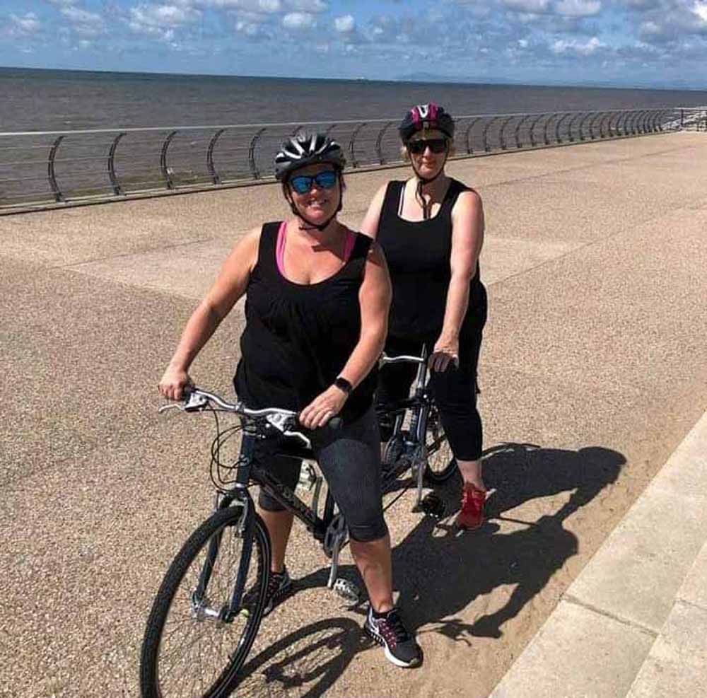 Nicky and her friend get to grips with a tandem bicycle (PA Real Life/Collect)