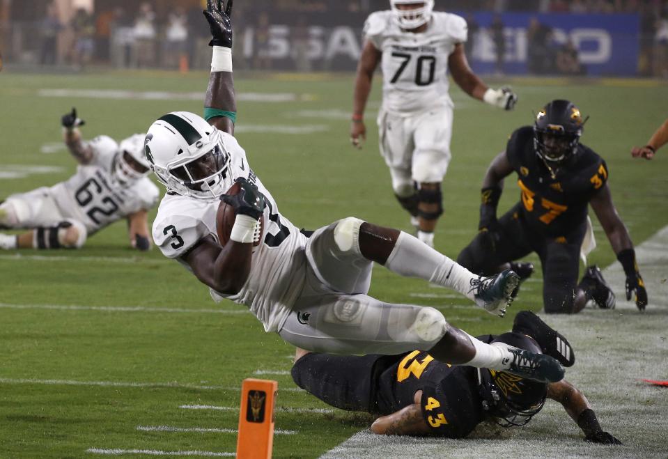 Michigan State running back LJ Scott (3) gets tackled by Arizona State safety Jalen Harvey (43) during the first half of an NCAA college football game Saturday, Sept. 8, 2018, in Tempe, Ariz. (AP Photo/Ross D. Franklin)