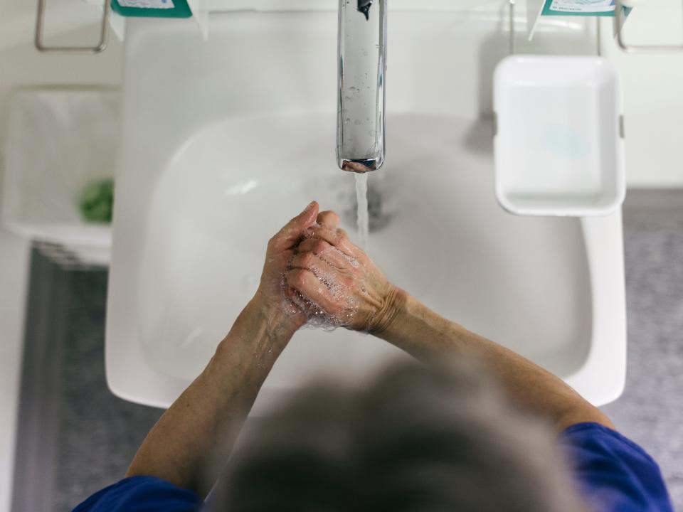 Person washing hands over sink.