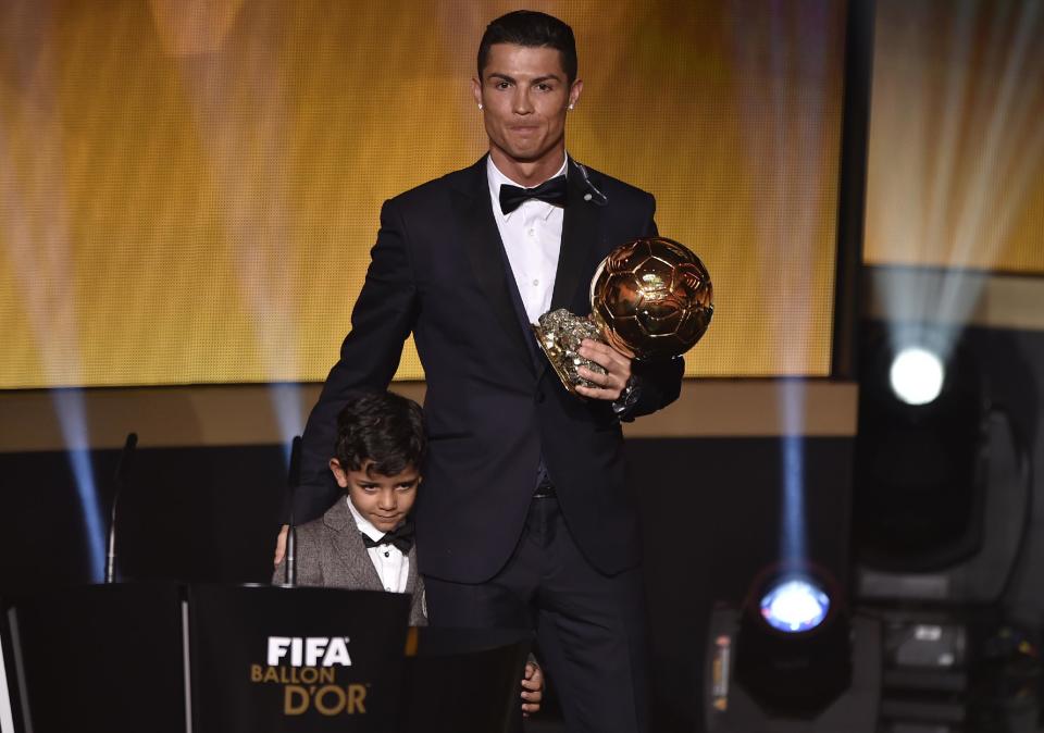 El delantero portugués del Real Madrid Cristiano Ronaldo posa junto a su hijo, Cristiano Jr,, tras recibir el Balón de Oro el 12 de enero de 2015 en Zúrich (AFP | Fabrice Coffrini)
