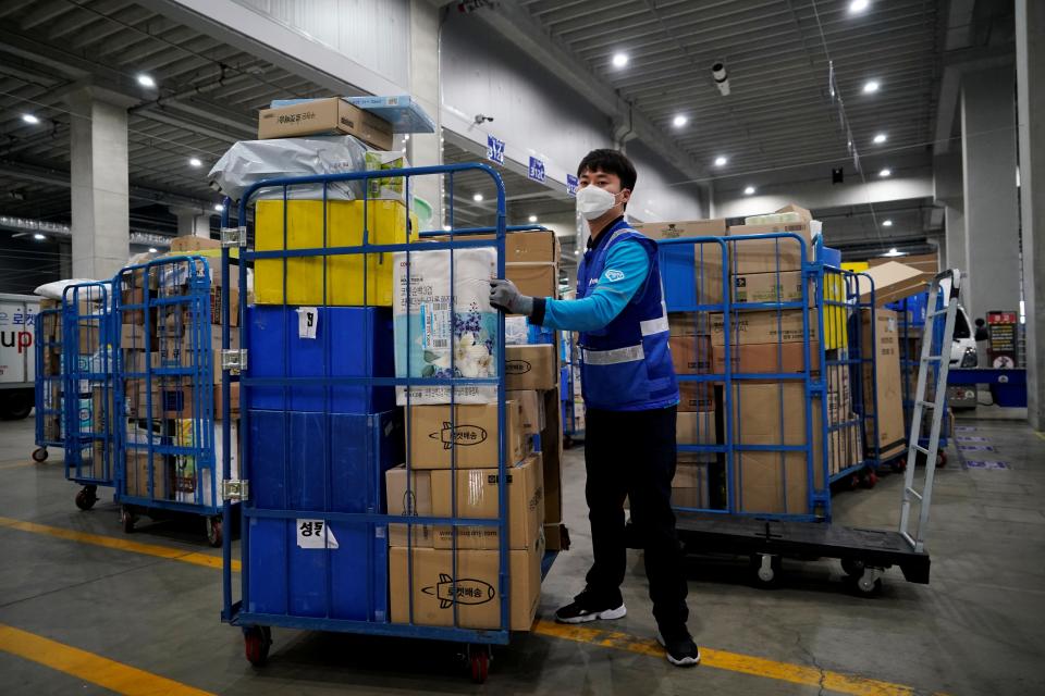 FILE PHOTO: A delivery man for Coupang Jung Im-hong wearing a mask to prevent contracting the coronavirus, loads packages before leaving to deliver them in Incheon, South Korea, March 3, 2020.   REUTERS/Kim Hong-Ji