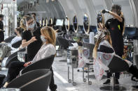 Clients get their hair done at a hairdresser in Milan, Italy, Monday, May 18, 2020 as Italy is slowly lifting sanitary restrictions after a two-month coronavirus lockdown. (Claudio Furlan/LaPresse via AP)