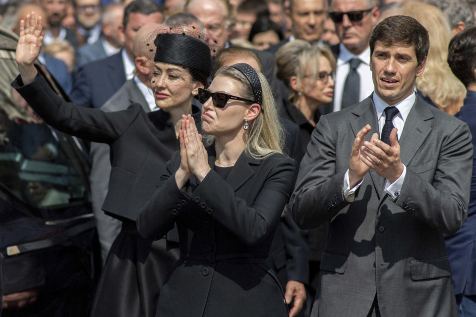 Family members of former Italian Premier Silvio Berlusconi, from left, daughters Eleonora and Barbara, and son Luigi, acknowledge the crowd at the end of Berlusconi's state funeral outside the Milan's Gothic Cathedral in northern Italy, Wednesday, June 14, 2023. Berlusconi died at the age of 86 on Monday in a Milan hospital where he was being treated for chronic leukemia. (Claudio Furlan/LaPresse via AP)