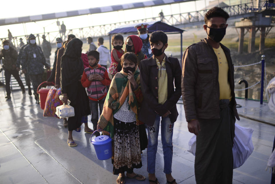 Rohingya refugees wait to board a naval ship to be transported to an isolated island in the Bay of Bengal, in Chittagong, Bangladesh, Tuesday, Dec. 29, 2020. Officials in Bangladesh sent a second group of Rohingya refugees to the island on Monday despite calls by human rights groups for a halt to the process. The Prime Minister’s Office said in a statement that more than 1,500 Rohingya refugees left Cox’s Bazar voluntarily under government management. Authorities say the refugees were selected for relocation based on their willingness, and that no pressure was applied on them. But several human rights and activist groups say some refugees have been forced to go to the island, located 21 miles (34 kilometers) from the mainland. (AP Photo/Mahmud Hossain Opu)