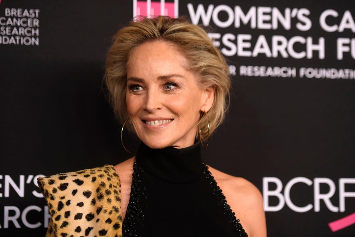 Sharon Stone looks breath-taking in this turtle neck dress with a leopard skin scarf on her shoulder