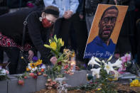 A demonstrator places flowers at a memorial outside Cup Foods as supporters gather to celebrate the murder conviction of former Minneapolis police officer Derek Chauvin in the killing of George Floyd, Tuesday, April 20, 2021, in Minneapolis. (AP Photo/John Minchillo)