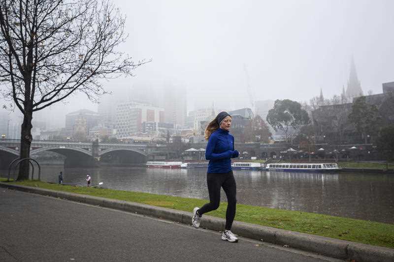 A woman is seen jogging along the Yarra River in Melbourne.