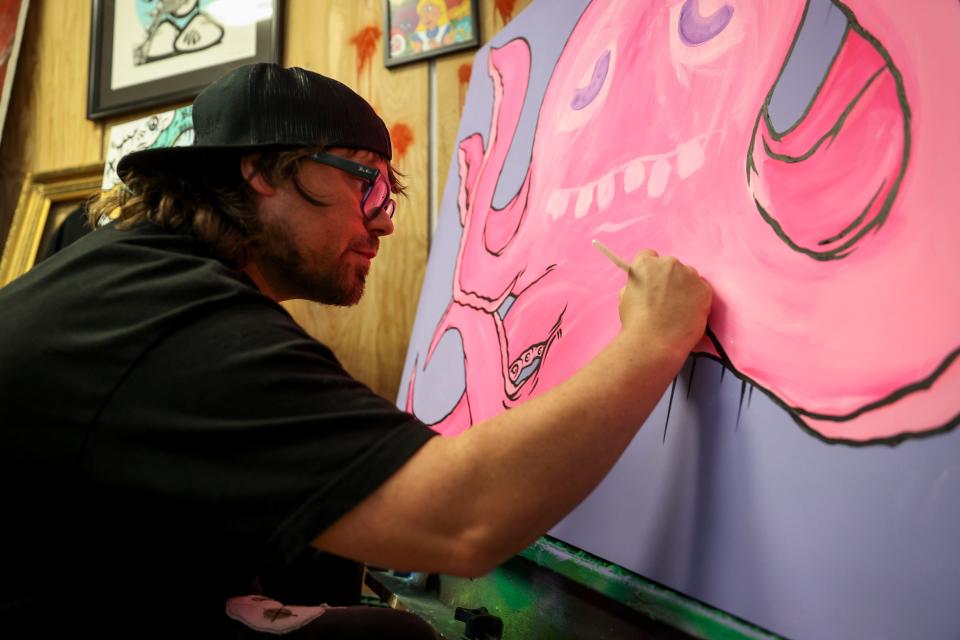 Jonezy works on the details of a painting at his studio on April 16 in Turner.