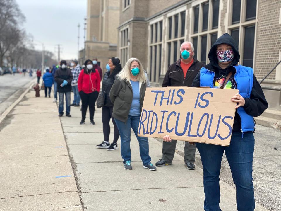 Jennifer Taff, holding a sign expressing her frustration with voting conditions on April 7, 2020, in Milwaukee, waits in line for almost two hours to vote, after being unable to get an absentee ballot to vote by mail during the start of the COVID-19 pandemic.