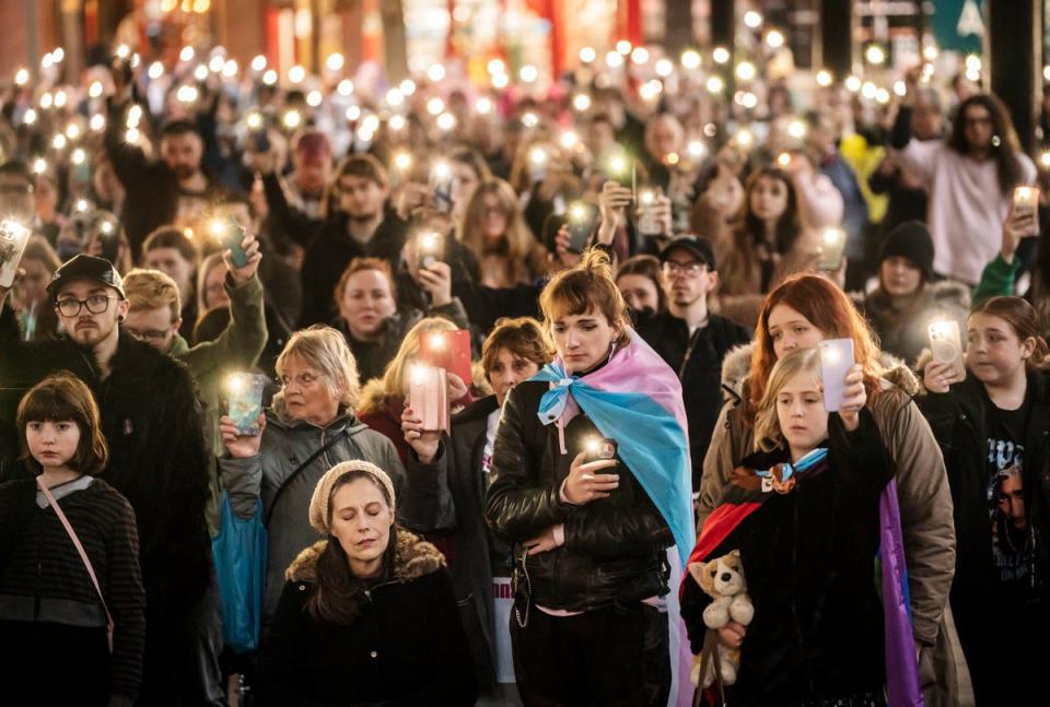 Members of the public hold their phones with the torch function set during a moment of silence as they attend a candle-lit vigil at Old Market Place in Warrington in memory of transgender teenager Brianna Ghey (PA)