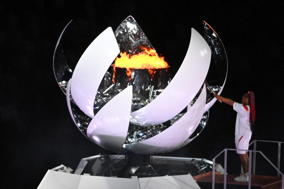 <p>Japanese tennis player Naomi Osaka lights the flame of hope in the Olympic Cauldron during the opening ceremony of the Tokyo 2020 Olympic Games, at the Olympic Stadium, in Tokyo, on July 23, 2021. (Photo by Martin BUREAU / AFP) (Photo by MARTIN BUREAU/AFP via Getty Images)</p> 