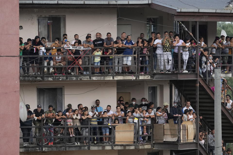 Residents watch Pope Francis meeting with members of the Roma community at Lunik IX, in Kosice, Slovakia, Tuesday, Sept. 14, 2021, the biggest of about 600 shabby, segregated settlements where the poorest 20% of Slovakia's 400,000 Roma live. Pope Francis traveled to Kosice, in the far east of Slovakia on Tuesday to meet with the country's Roma in a gesture of inclusion for the most socially excluded minority group in Slovakia, who have long suffered discrimination, marginalization and poverty. (AP Photo/Petr David Josek)