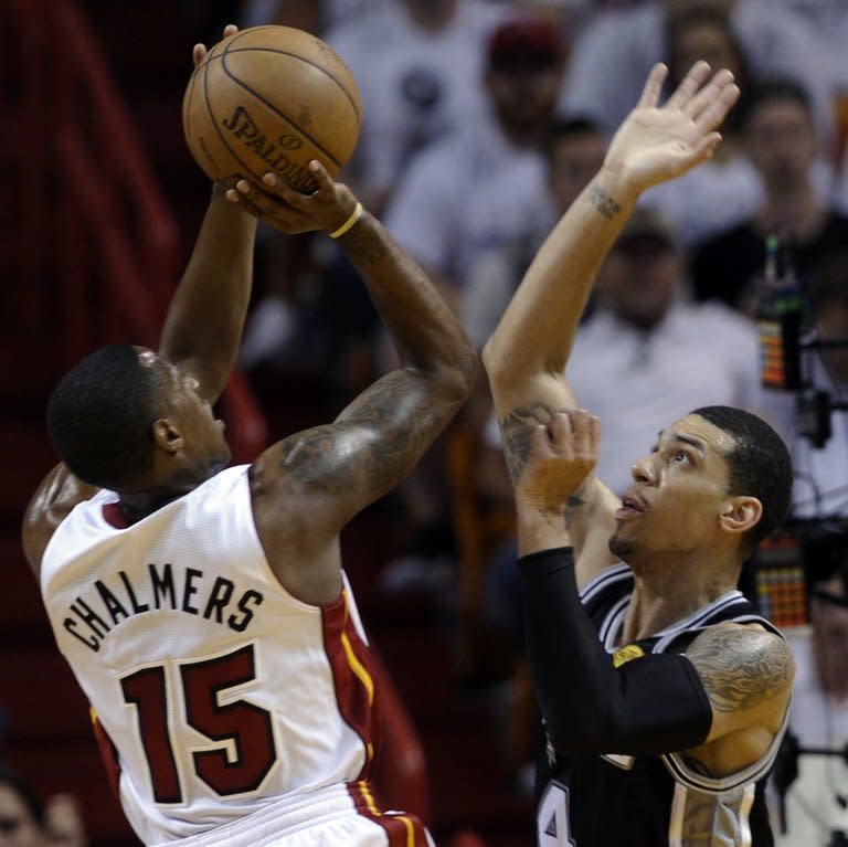 Mario Chalmers (L) of the Miami Heat shoots past Danny Green of the San Antonio Spurs during their game on June 9, 2013. Green scored the first nine points for San Antonio as he nailed three from beyond the arc to give the Spurs a 9-4 lead with 8:43 left