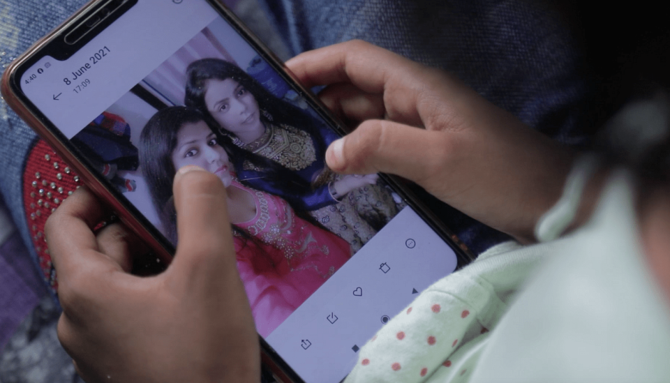 <div class="paragraphs"><p>Naziya looking at her mother's photo on her phone. </p></div>