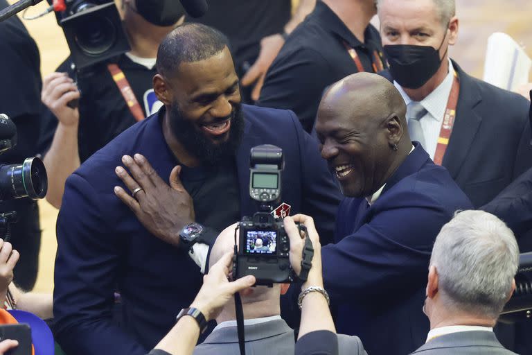 James y Michael Jordan se saludan en la presentación de los 75 jugadores más grandes de la historia de la NBA, antes del Partido de las Estrellas de 2022 en Cleveland; el ex astro de Chicago Bulls superó los 1.000.000.000 de dólares sólo una vez retirado, ya como inversor.