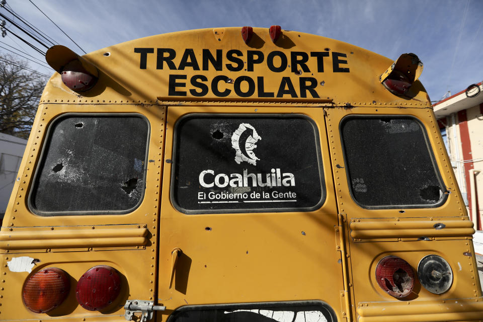 A school bus with bullet holes sits parked outside City Hall in Villa Union, Mexico in Monday, Dec. 2, 2019. The small town near the U.S.-Mexico border began cleaning up Monday even as fear persisted after 22 people were killed in a weekend gunbattle between a heavily armed drug cartel assault group and security forces. (AP Photo/Eduardo Verdugo)