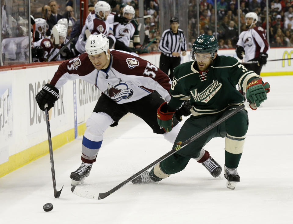 Colorado Avalanche left wing Cody McLeod (55) and Minnesota Wild defenseman Nate Prosser (39) chase the puck during the second period of Game 6 of an NHL hockey first-round playoff series in St. Paul, Minn., Monday, April 28, 2014. (AP Photo/Ann Heisenfelt)