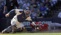 Cincinnati Reds right fielder Nick Castellanos (2) slides into home ahead of the tag by Milwaukee Brewers catcher Manny Pina (9) during the fourth inning of a baseball game Wednesday, June 16, 2021, in Milwaukee. (AP Photo/Jeffrey Phelps)