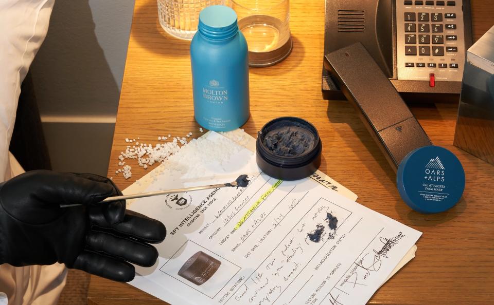 The SPY dips a tester into a face mask placed on a bedside table.