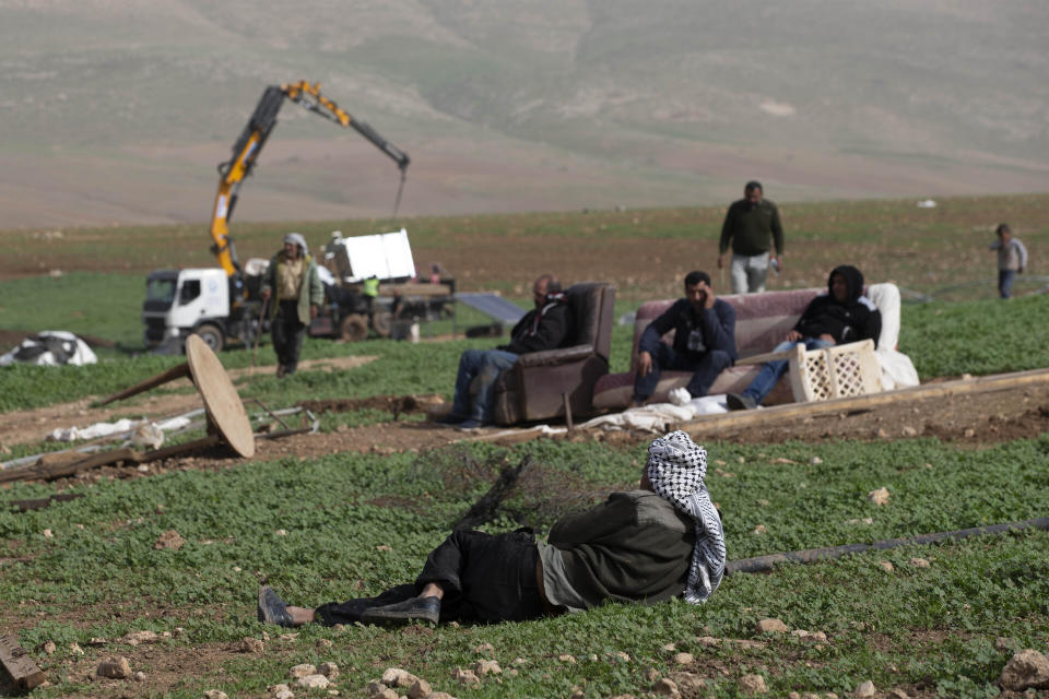 FILE - In this Feb. 3, 2021, file, photo, Palestinian Bedouin watch Israeli troops demolish tents and other structures of Khirbet Humsu hamlet in the Jordan Valley in the West Bank. A battle of wills is underway in the occupied West Bank, where Israel has demolished the herding community of Khirbet Humsu three times in as many months, displacing dozens of Palestinians. Each time they have returned and tried to rebuild, saying they have nowhere else to go. (AP Photo/Majdi Mohammed)