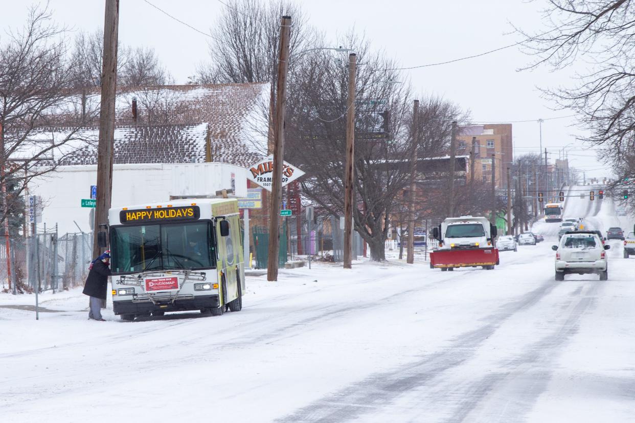 City buses continue on their routes, picking up a passenger Thursday morning on S.E. 6th Avenue, after snow covered the area the night before.