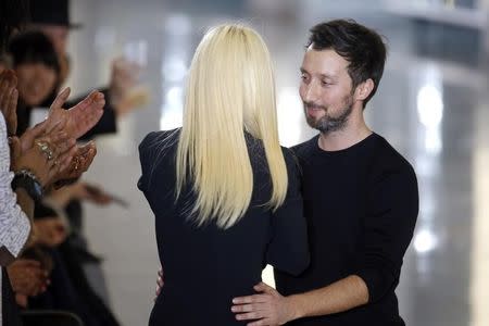 Italian designer Donatella Versace (L) greets designer Anthony Vaccarello at the end of his Autumn/Winter 2015/2016 women's ready-to-wear collection show during Paris Fashion Week March 3, 2015. REUTERS/Charles Platiau