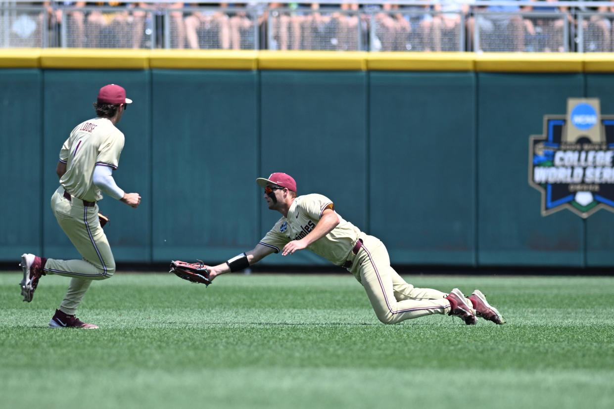 Jun 16, 2024; Omaha, NE, USA; Florida State Seminoles center fielder Max Williams (18) makes a catch against the Virginia Cavaliers during the fifth inning at Charles Schwab Field Omaha.