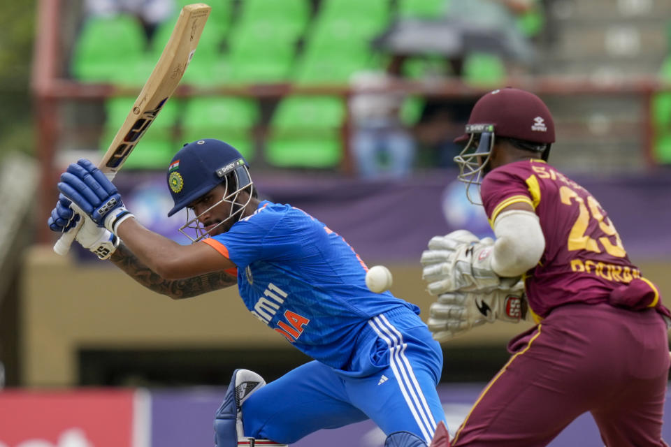 India's Tilak Varma lets a ball pass under the watch of West Indies' Nicholas Pooran during the third T20 cricket match at Providence Stadium in Georgetown, Trinidad and Tobago, Tuesday, Aug. 8, 2023. (AP Photo/Ramon Espinosa)